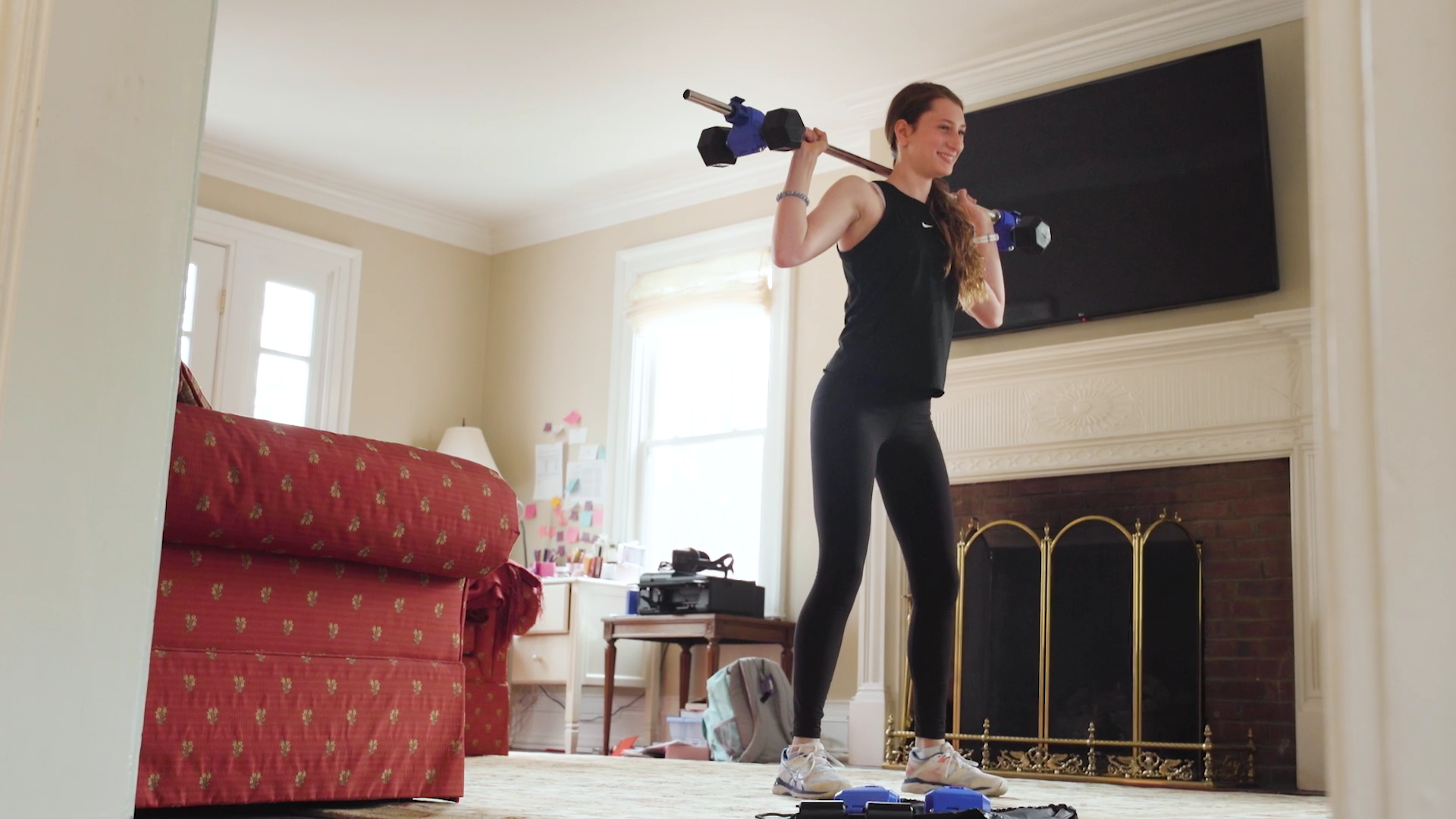 female doing barbell squats with dumbbells on bar using Dualbell