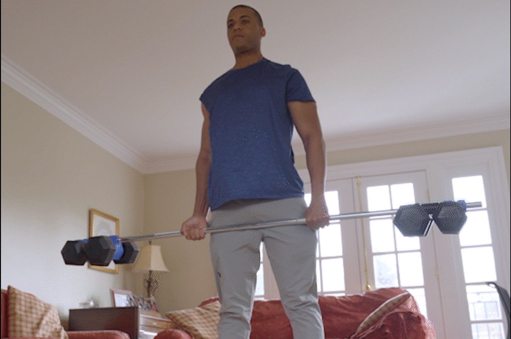male in home gym doing barbell deadlifts with dumbbells on bar connected with Dualbell